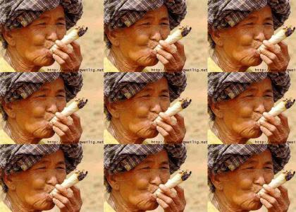 Old chinese man smokes a huge bud.